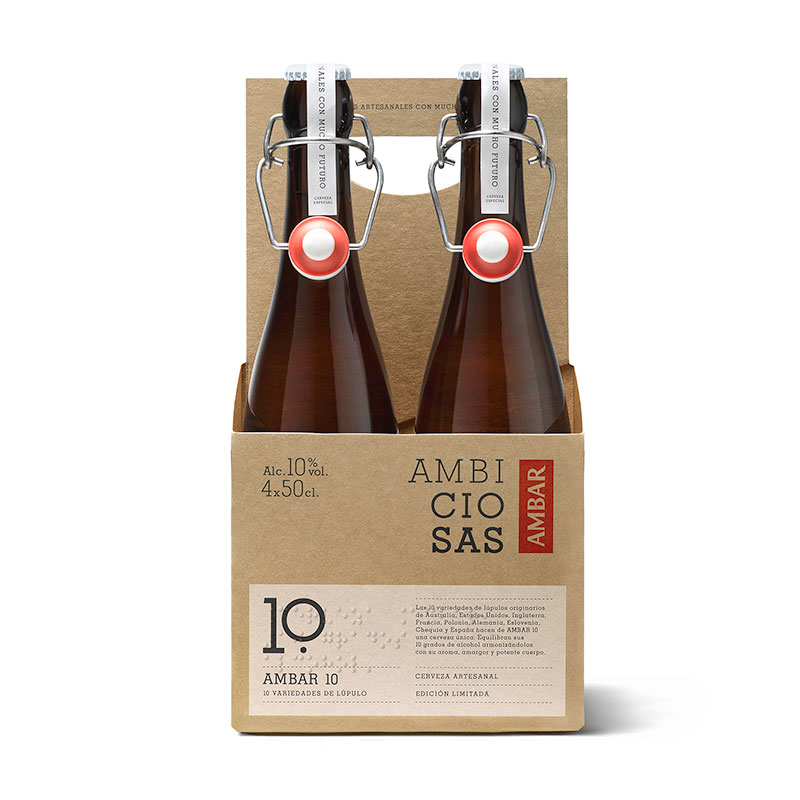 
Embalaje de cartón con dos botellas de cerveza Ambiciosas Ámbar. En el frontal del cartón se ven unas letras en braille con el nombre del producto y marca.
